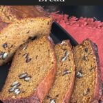 Sweet potato bread sliced on a dark platter.