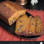 Sweet potato bread sliced on a dark platter.