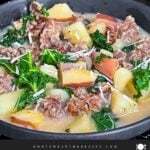 Sausage, potato and kale soup (Zuppa Toscana) in dark bowls on a dark surface.