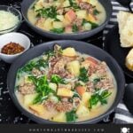 Sausage, potato and kale soup (Zuppa Toscana) in dark bowls on a dark surface.