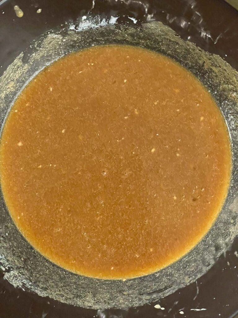 Wet ingredients and sugar for baked apple cider donuts combined in a glass mixing bowl.