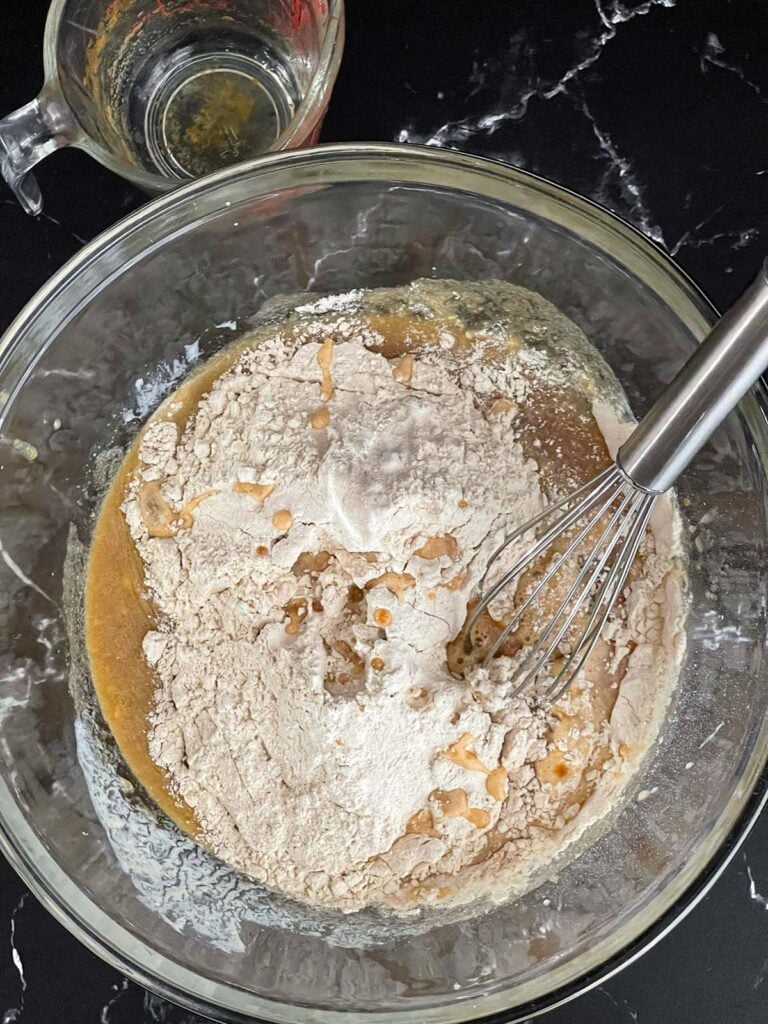 Dry ingredients added to the wet ingredients for baked apple cider donuts.