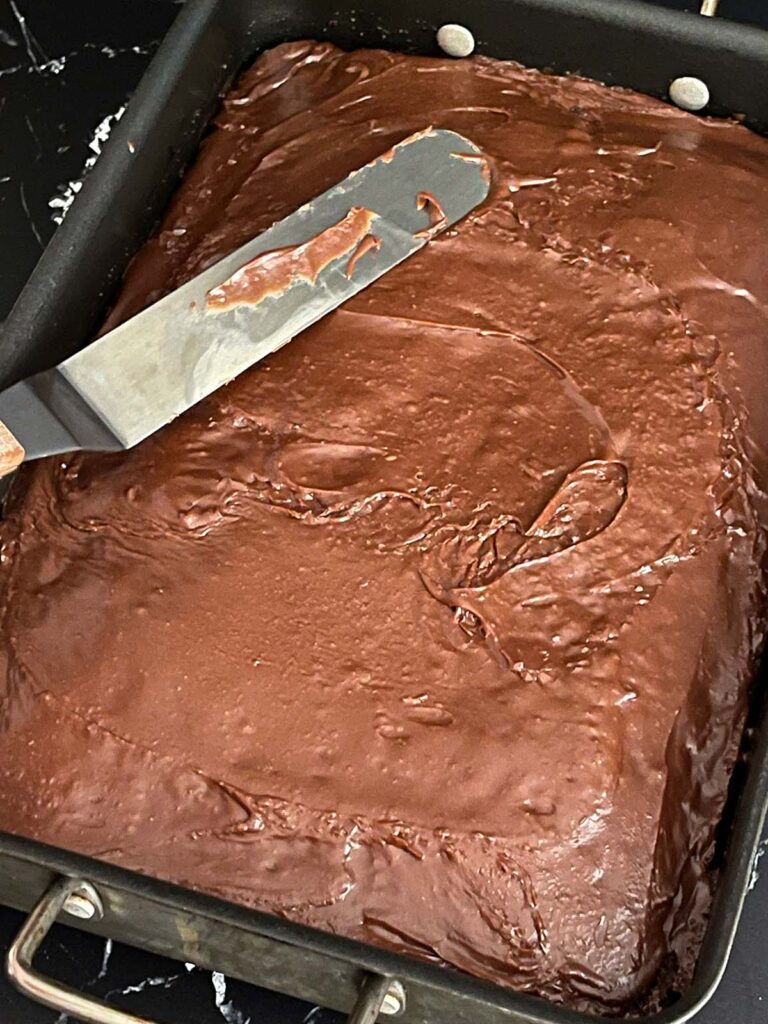 Chocolate icing spread over the buttermilk brownies in the baking pan.