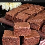 Three buttermilk brownies on a dark plate on a dark surface.