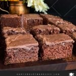 Sliced buttermilk brownies on a wooden cutting board.