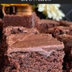 Sliced buttermilk brownies on a wooden cutting board.