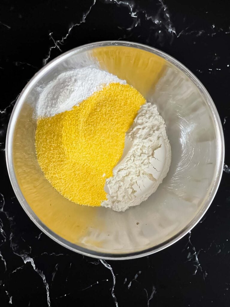 Flour and cornmeal in a stainless steel bowl.