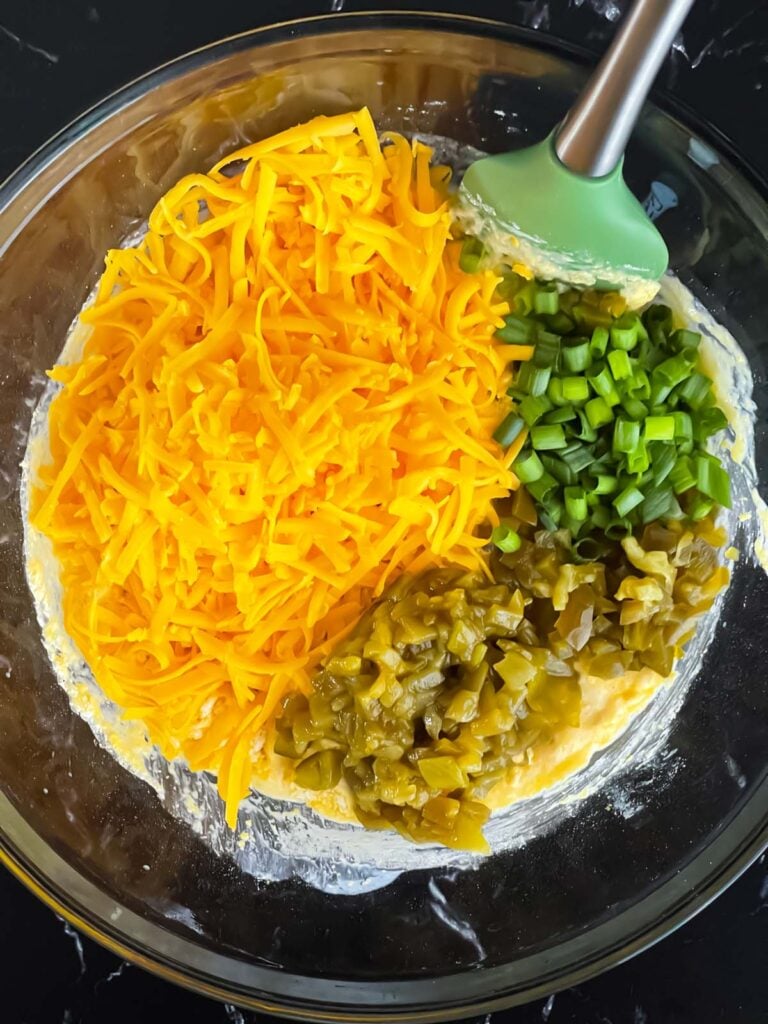 Adding additional ingredients to a cornbread batter.