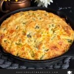 Cheddar jalapeno cornbread, cooked, in a cast iron skillet.