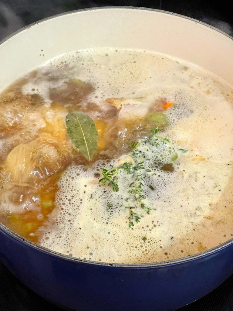Chicken noodle soup simmering in a large dutch oven.