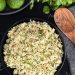 Cilantro lime rice in a dark bowl on a dark surface.