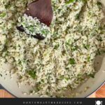 Cilantro lime rice in a dark bowl on a dark surface.