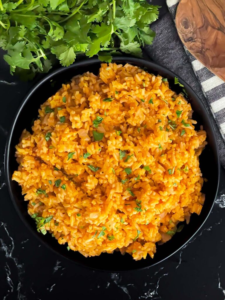 Mexican red rice in a dark bowl.
