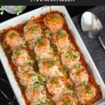 Easy baked parmesan meatballs garnished with chopped Italian flat leaf parsley in a light casserole dish.