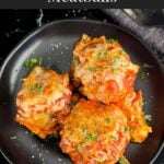 Easy baked parmesan meatballs garnished with chopped Italian flat leaf parsley on a dark plate.