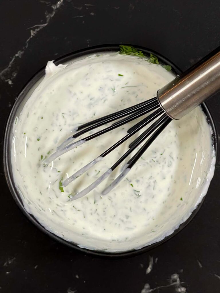 Cilantro lime cream sauce mixed in a black bowl.