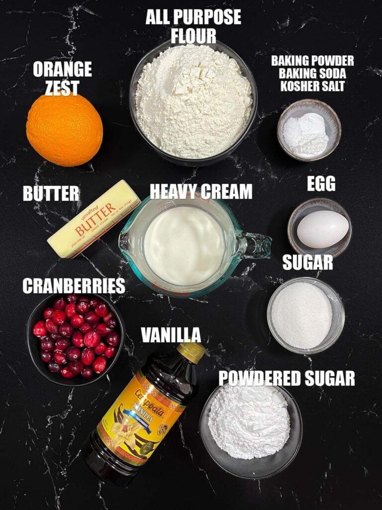 Cranberry orange scones recipe ingredients on a dark surface.