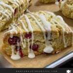 Cranberry orange scones on a parchment paper lined baking pan.