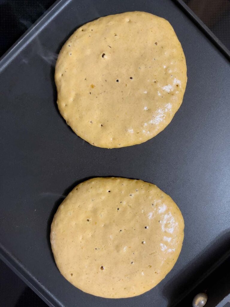 Bubbles popping on pumpkin pancake before flipping.