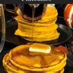 Stack of fluffy pumpkin pancakes with butter and maple syrup, golden edges on a dark plate.