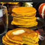 Stack of fluffy pumpkin pancakes with butter and maple syrup, golden edges on a dark plate.