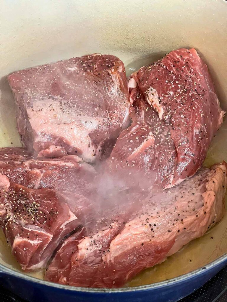Pork shoulder browning in a dutch oven.
