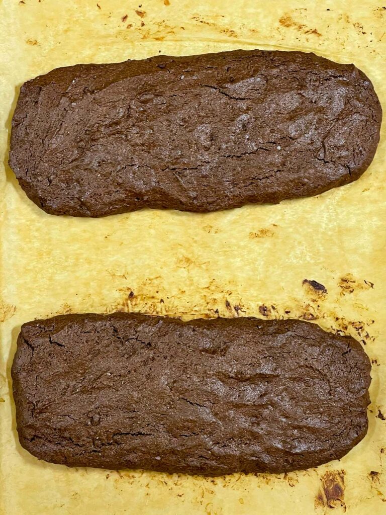 The two chocolate peppermint biscotti logs baked on the baking sheet.