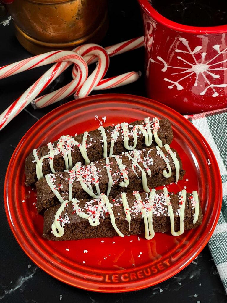 Three chocolate peppermint biscotti on a plate.