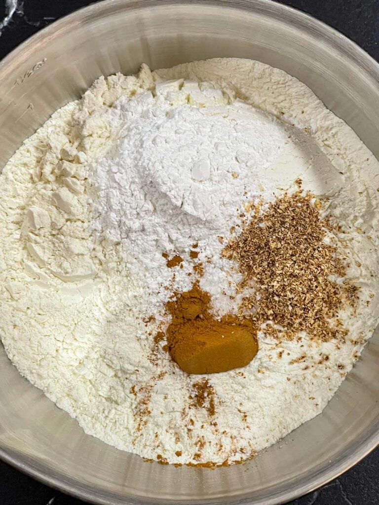 Dry ingredients for the eggnog muffins recipe in a metal bowl.