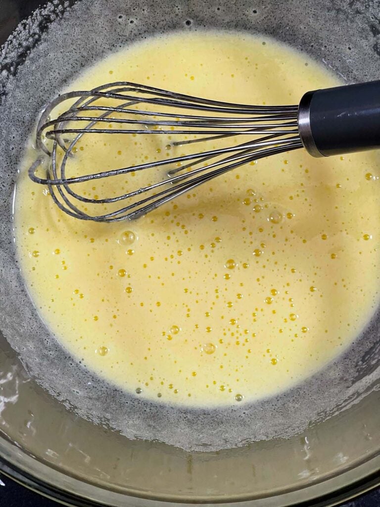 Eggs and sugar whisked together until thick for the eggnog muffins recipe.