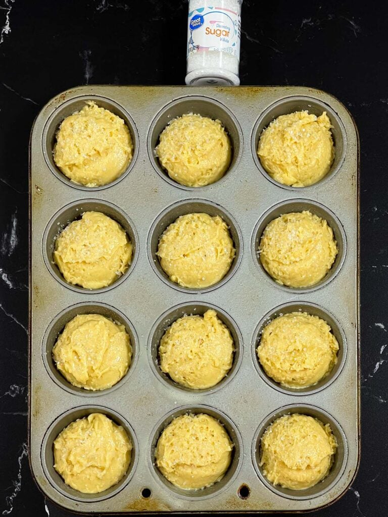 Eggnog muffin batter divided evenly into a muffin pan.