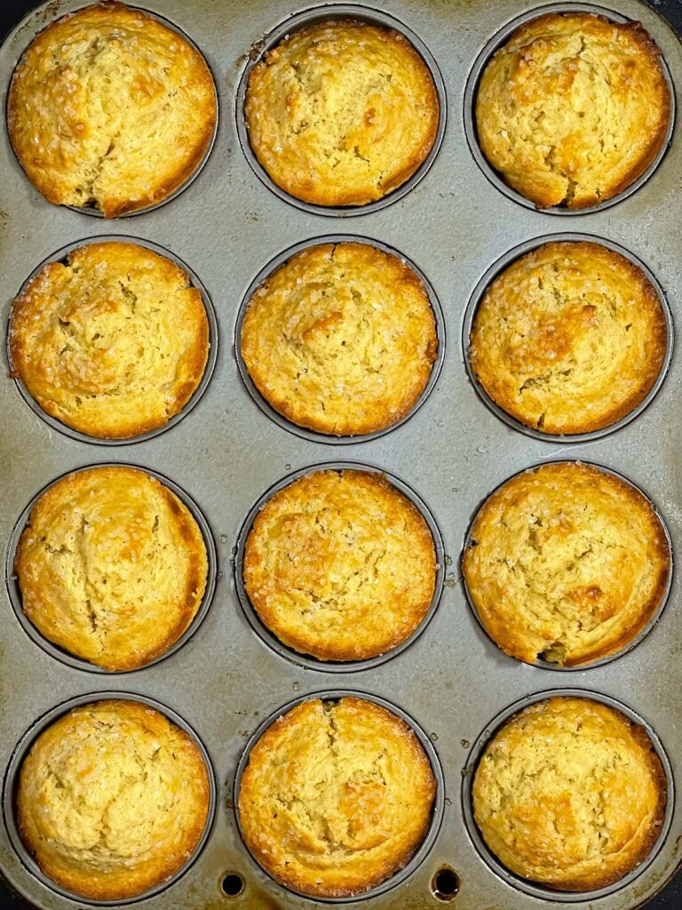 Baked eggnog muffins in a muffin pan.