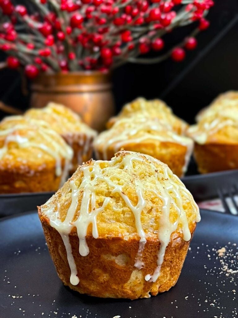 Eggnog muffin garnished with grated nutmeg on a dark plate.