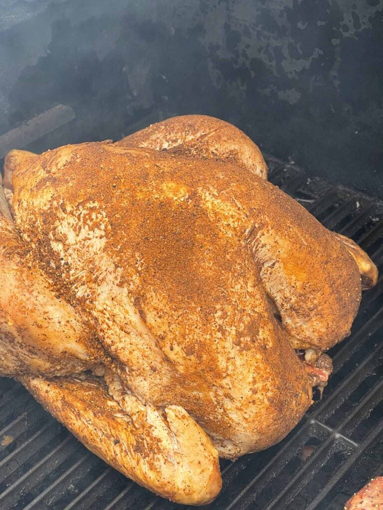 A turkey on a smoker, covered in spices.