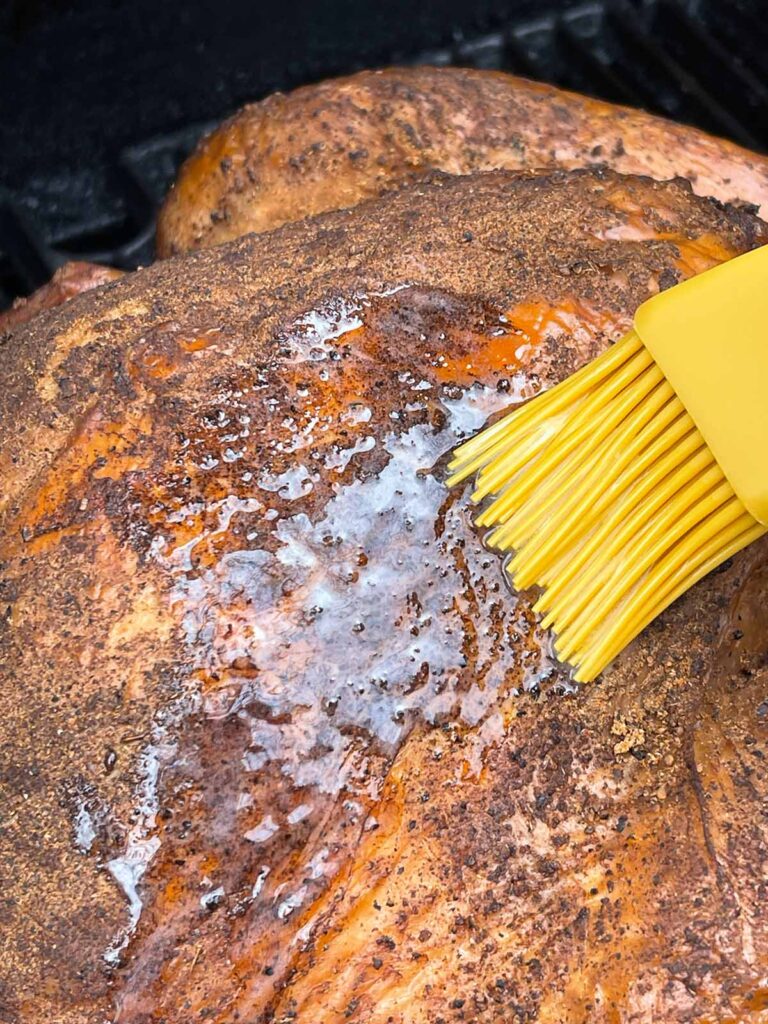 A turkey being basted with butter.