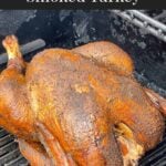 A whole smoked turkey in a smoker.