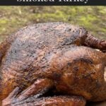 A whole smoked turkey on a wooden cutting board.