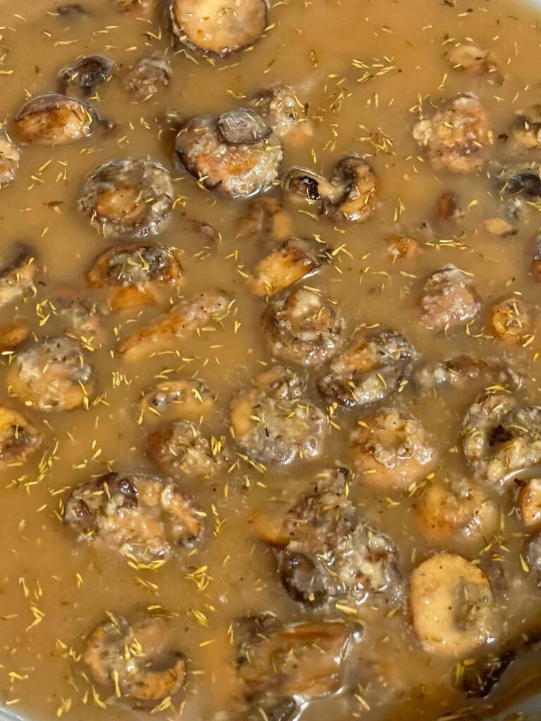 Mushroom gravy simmering and thickening in skillet