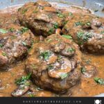 Salisbury steak with mushroom gravy served over mashed potatoes with green beans and bread