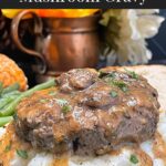 Salisbury steak with mushroom gravy served over mashed potatoes with green beans and bread