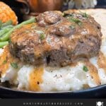 Salisbury steak with mushroom gravy served over mashed potatoes with green beans and bread