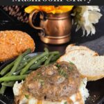 Salisbury steak with mushroom gravy served over mashed potatoes with green beans and bread