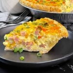A slice of Western Omelet Quiche on a dark plate.