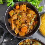 Guinness beef stew in a dark bowl.