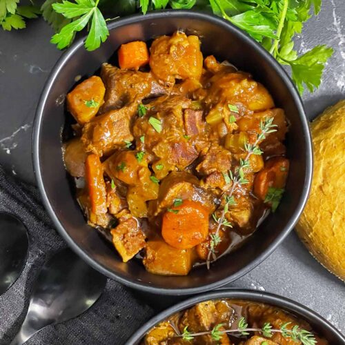 Guinness beef stew in a dark bowl.