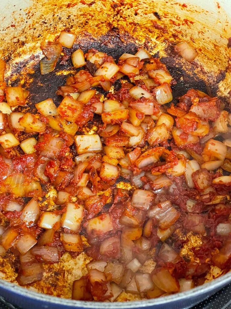 Tomato paste and onions in a dutch oven.