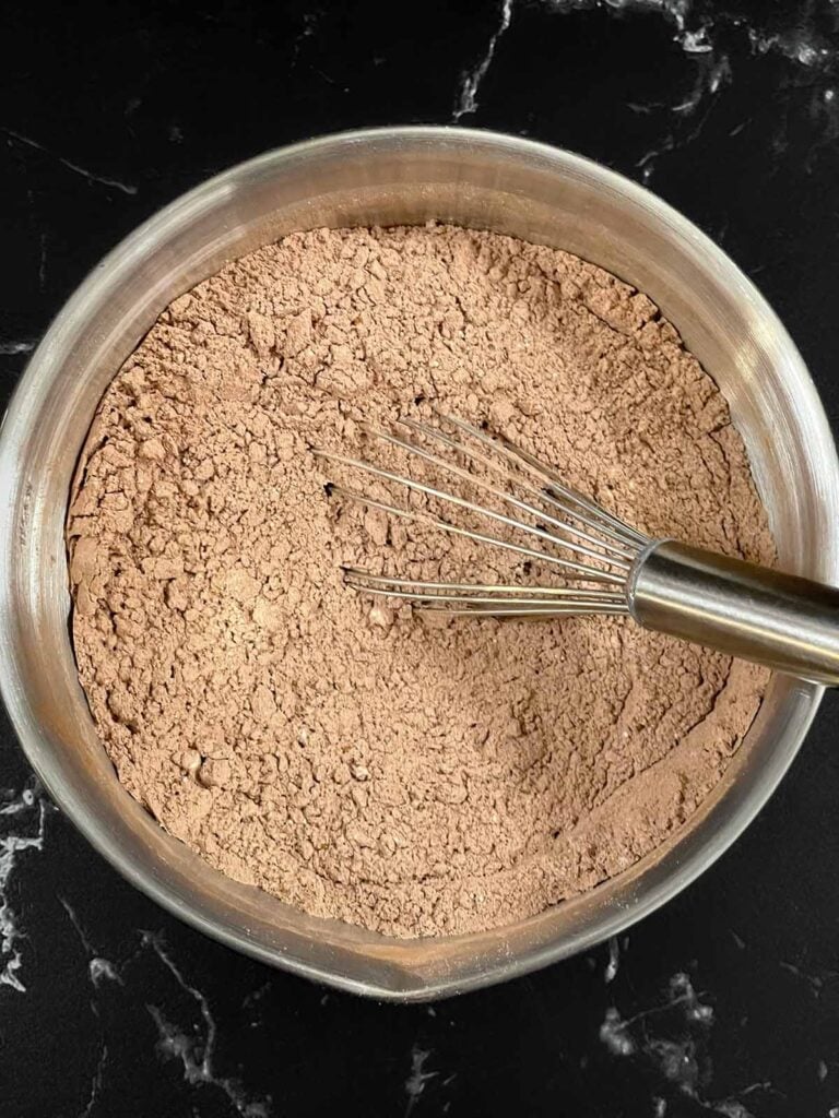 Dry ingredients for the chocolate Kahlua cake recipe whisked together in a metal bowl.