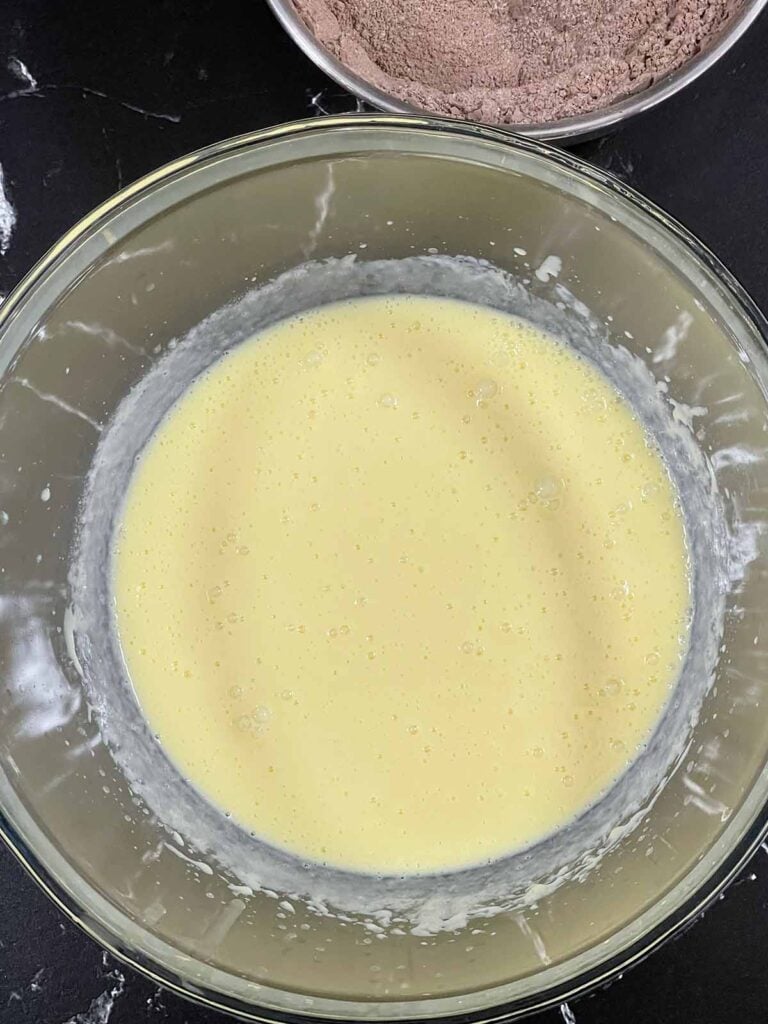 Wet ingredients for the chocolate Kahlua cake recipe whisked together in a glass bowl.