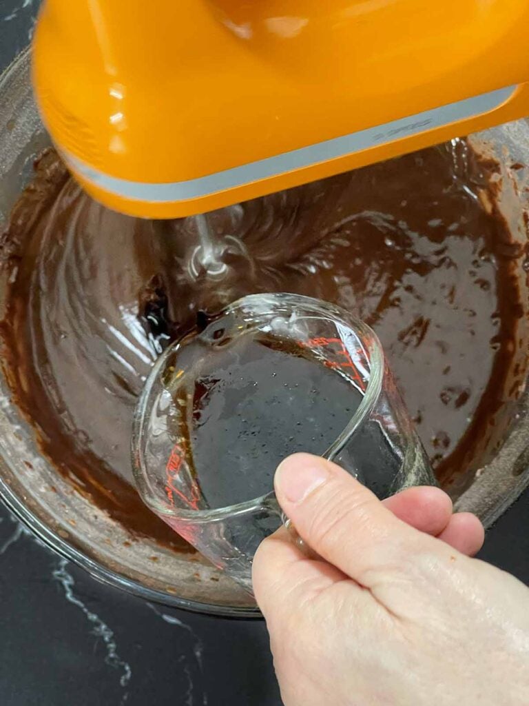 Hot coffee being added to the chocolate Kahlua cake batter.