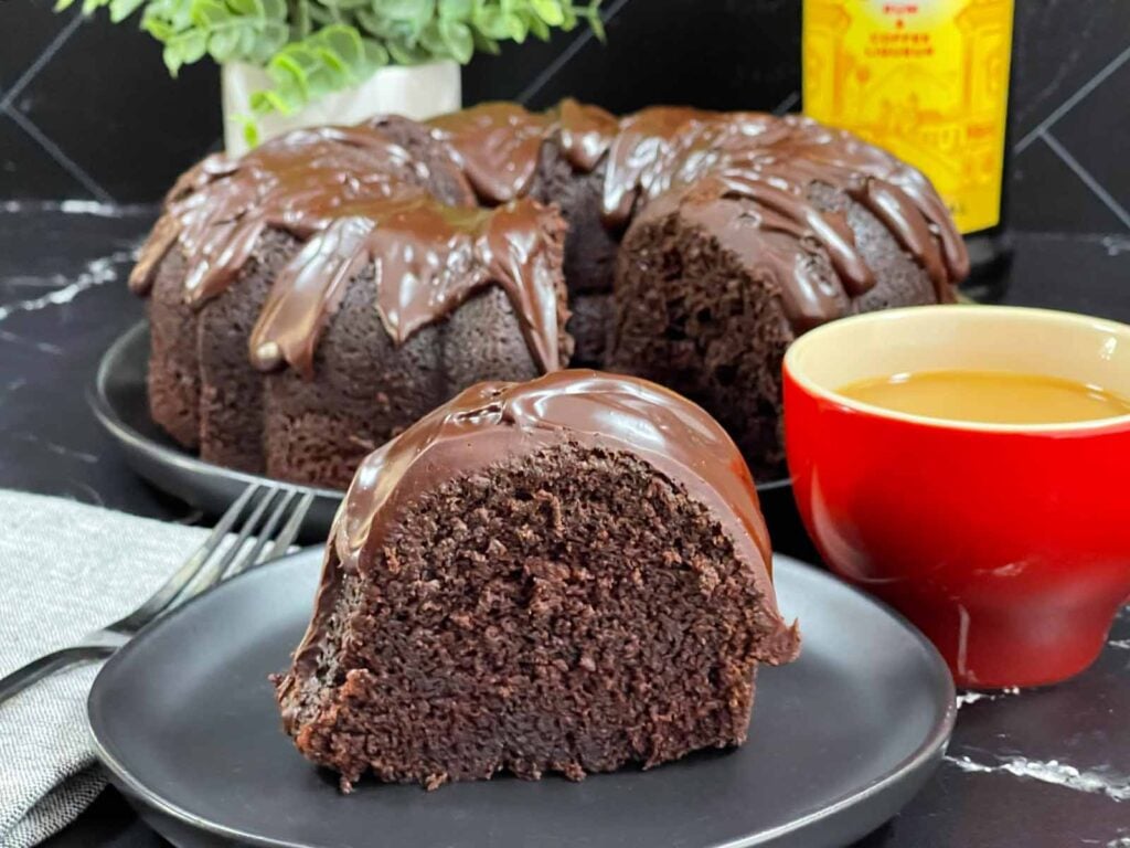 A slice of chocolate Kahlúa cake on a dark plate.